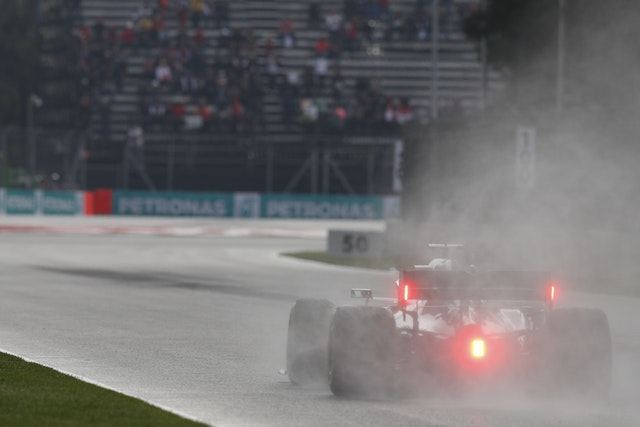 Lewis Hamilton's car throws up spray on the wet track in Mexico
